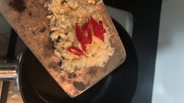 蒜蓉拌秋葵,另起一锅烧热下油,倒入蒜末和辣椒粒翻炒