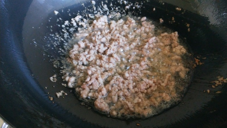 豌豆炒肉末 新文美食,倒入猪肉馅快速炒散。