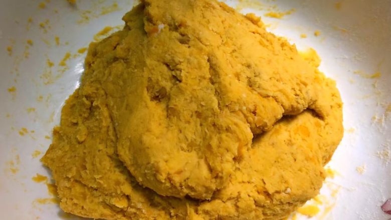 红薯饼,戴上手套,把糯米粉和红薯泥揉成团。