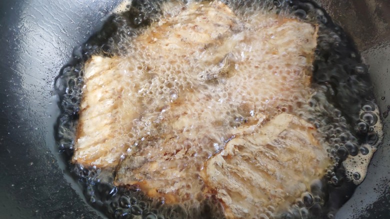豆豉带鱼(不腥的窍门),沾匀淀粉的鱼块入油锅炸成金黄色捞出。