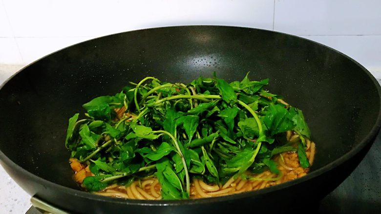 枸杞苗炒粉条,加入枸杞苗,快速翻炒几下,枸杞苗的叶子是很嫩的,只炒两下就可以了,只是过一下锅断生。