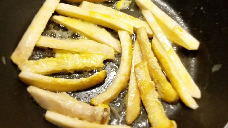 椒香杏鲍菇笋条#爽口凉菜#,鸡蛋打散 杏鲍菇条蘸上鸡蛋液 放到热油里煎成金黄色