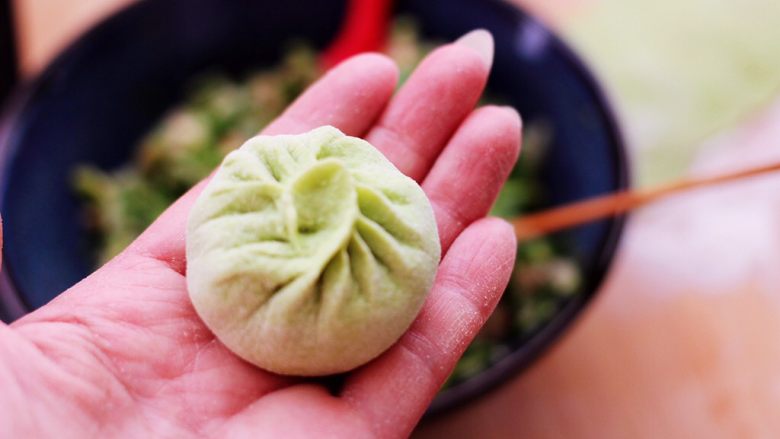 双色西葫芦韭菜生煎包,捏褶子收口,包成圆形的包子即可。