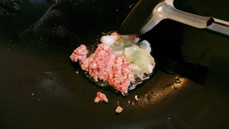 烤鱿鱼包饭,锅水热少许油,放入肉末和鱿鱼籽,翻炒。