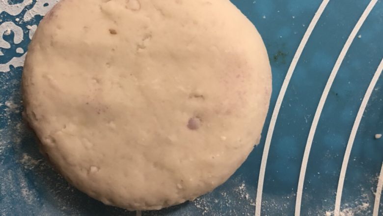 土豆紫薯饼,按包团子的方法给它包好,收口朝下,按扁。把所有的小剂子都按上面那样做好。