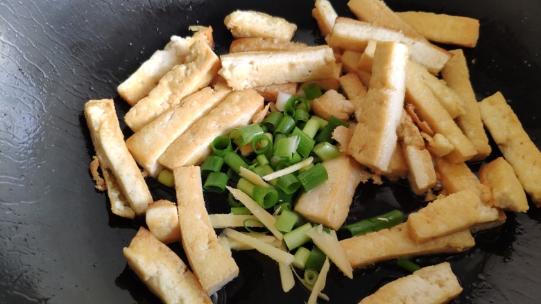 蒜薹炒豆腐,豆腐条煎好后，放入葱姜炒香。