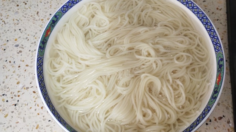 鸡蛋碎肉拌面,面条煮熟后,夹到大碗里备用,再加入清水搅拌,避免黏成一团