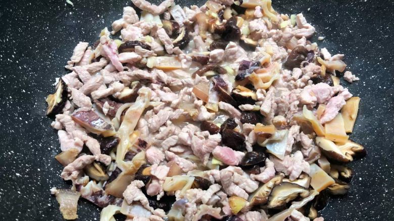 焖笋饭,加入姜末炒出香味,再加入香菇和墨鱼翻炒一下,盖上盖子焖5分钟。