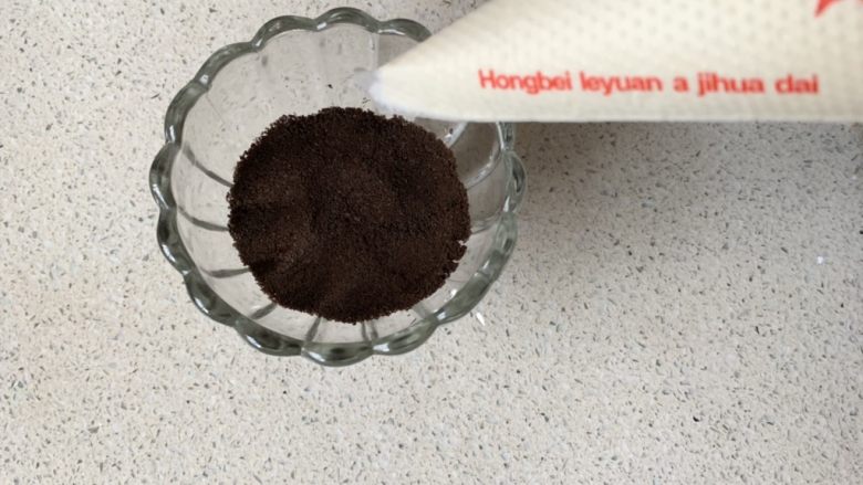 奥利奥木糠杯,先放2勺饼干碎,用勺子压压平