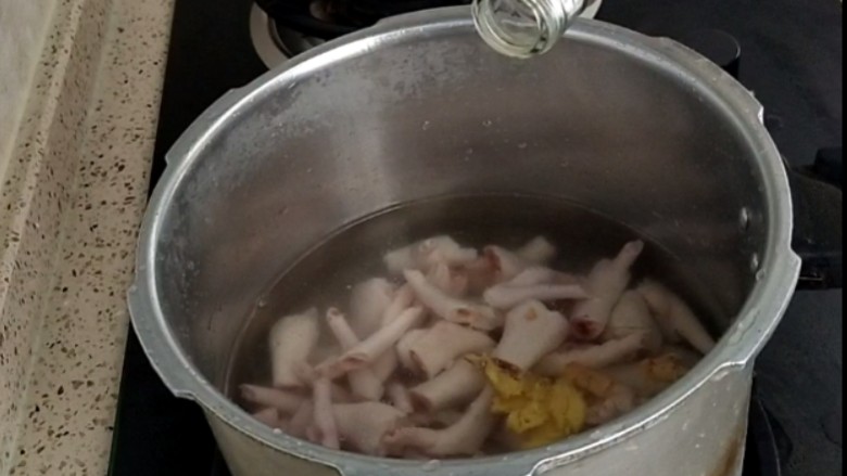 香卤鸡爪,把洗净的鸡爪放入锅中,加入清水,放入拍碎的姜,两勺料酒