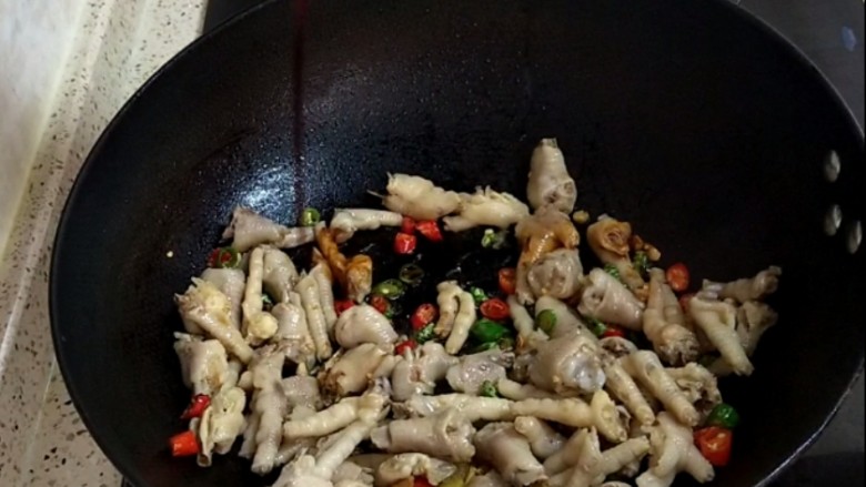 香卤鸡爪,煸炒均匀后,滴入两勺酱油