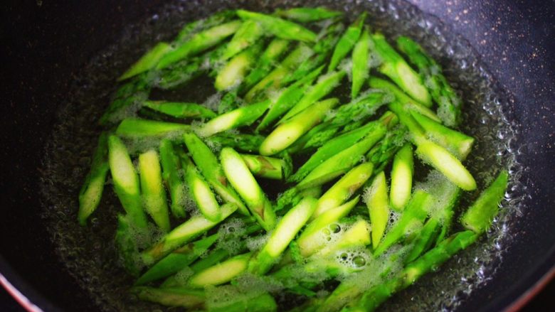 芦笋炒肉,锅里烧开水,加入少量的盐,食用油,能保持蔬菜颜色不变,把切好的芦笋,倒入烧开的水里烫至变色断生的时候,捞出备用。