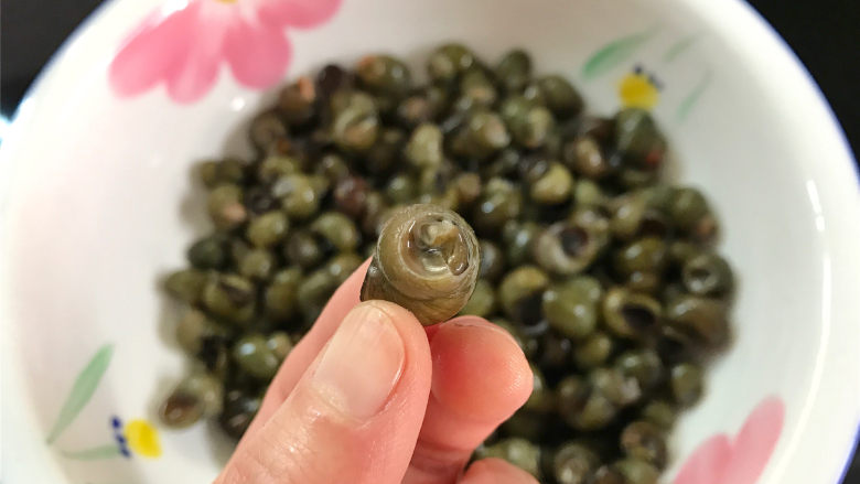 酱爆香辣螺蛳,然后用剪刀剪去螺蛳尾部,清洗干净后再放在容器中用清水养30分钟。
