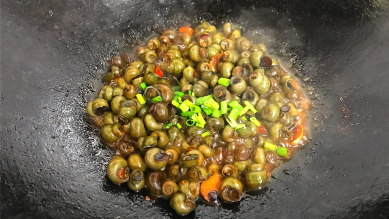 酱爆香辣螺蛳,熄火前撒入香葱,关火盛盘,上桌。