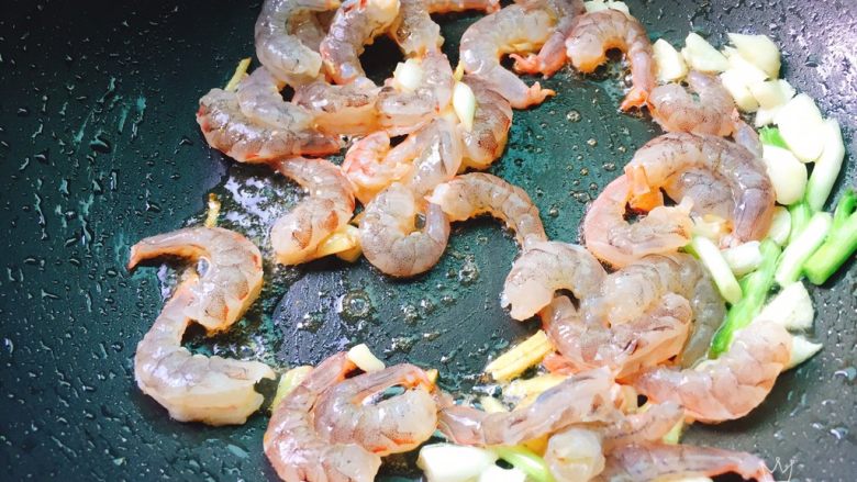 荷兰豆炒虾仁,锅烧热后入油烧至6成热爆香大蒜末,姜丝和葱白段,再把大虾放到锅里小火慢慢煎出红虾油变色