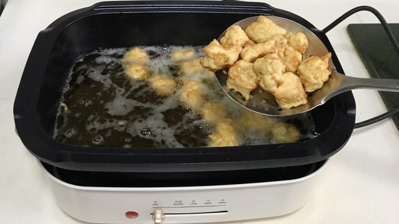 菠萝咕噜肉,待油温升高之后，继续入锅中复炸一次，捞出备用。