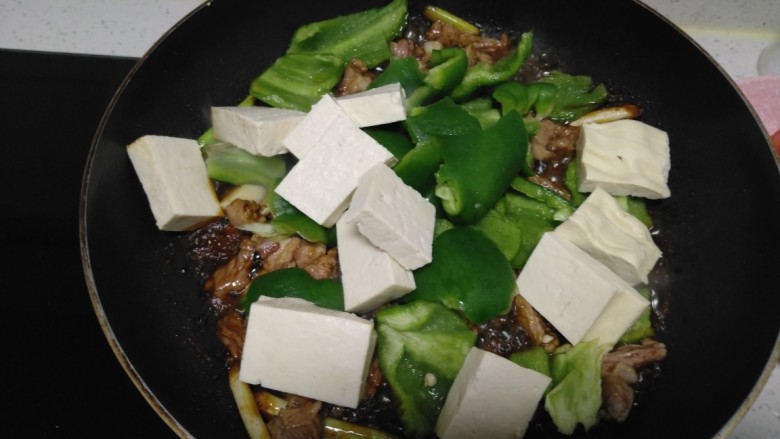 羊肉、菜椒、豆腐炒槐花骨累,放入豆腐。