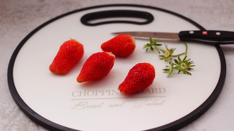 番茄草莓蜂蜜汁,用刀先把<a style='color:red;display:inline-block;' href='/shicai/ 592'>草莓</a>的根蒂切出。