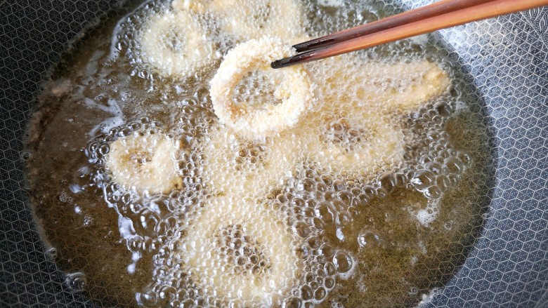 香酥鱿鱼圈,锅中宽油,烧至6成热,转小火,放入鱿鱼圈。