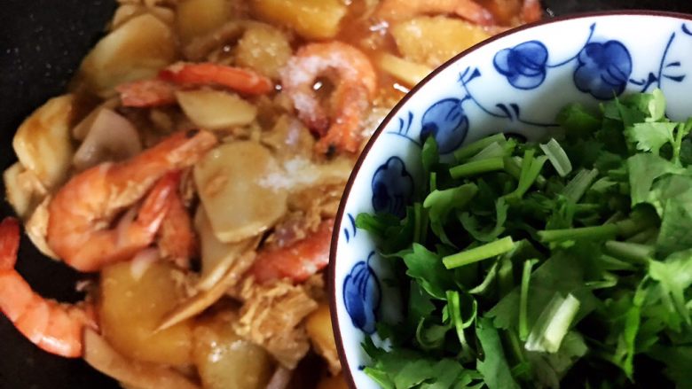 大虾土豆腐竹杏鲍菇年糕锅,加入香菜,翻炒均匀即可