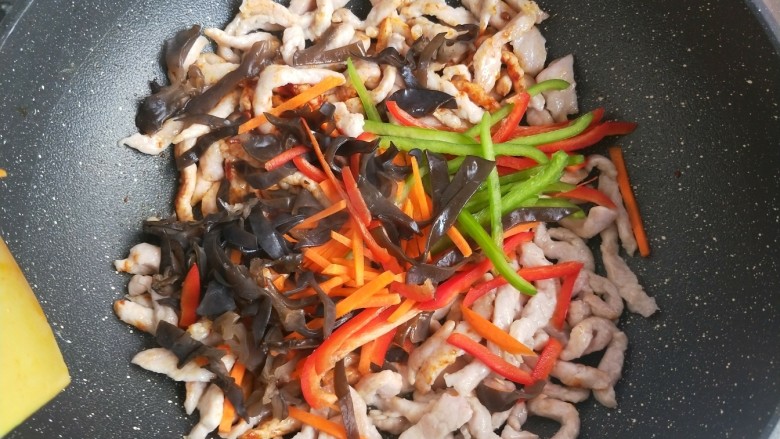 鱼香肉丝,接着倒入配菜翻炒,炒到配菜变软,断生。最后倒入蒜末。