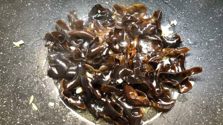 荷塘小炒,热锅放入适量油,烧至7成热,放入蒜末爆香,再把木耳放入翻炒1分钟。