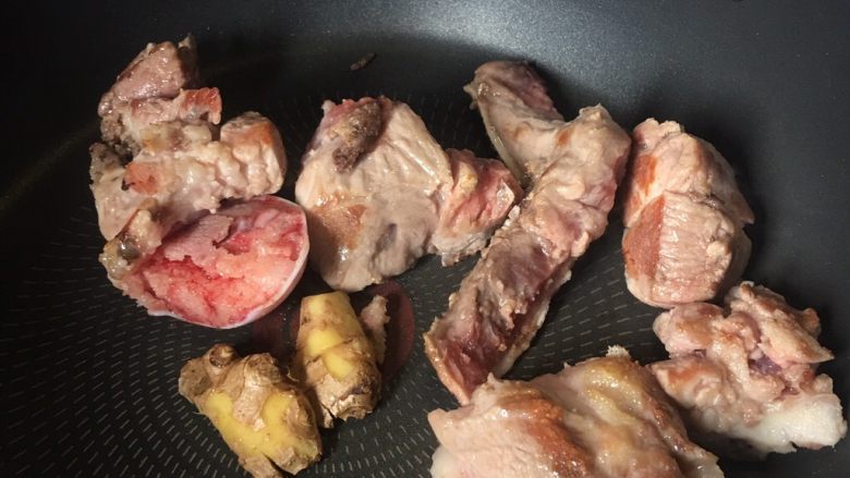 夏天汤水--猪骨眉豆节瓜汤,另一边,用平底锅煎猪扇骨,记得放姜。将扇骨两边煎香。