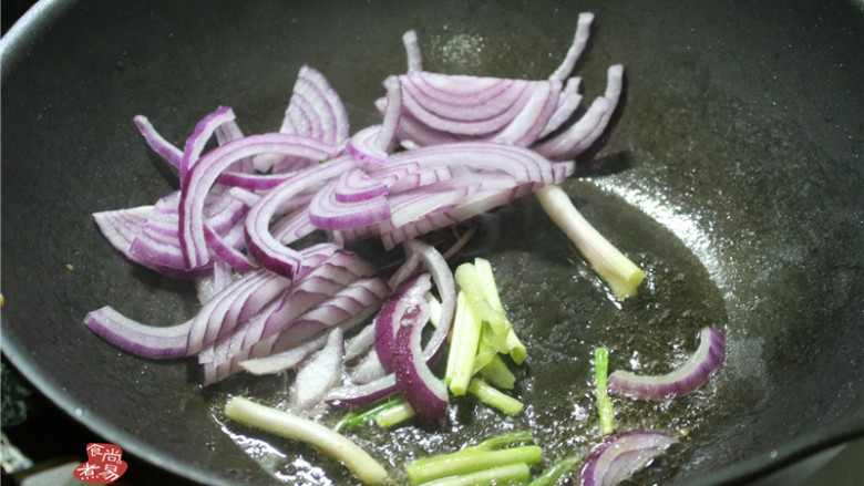 洋葱鸡蛋炒河粉,原锅继续烧热,加点食用油,将葱梗和洋葱炒香。