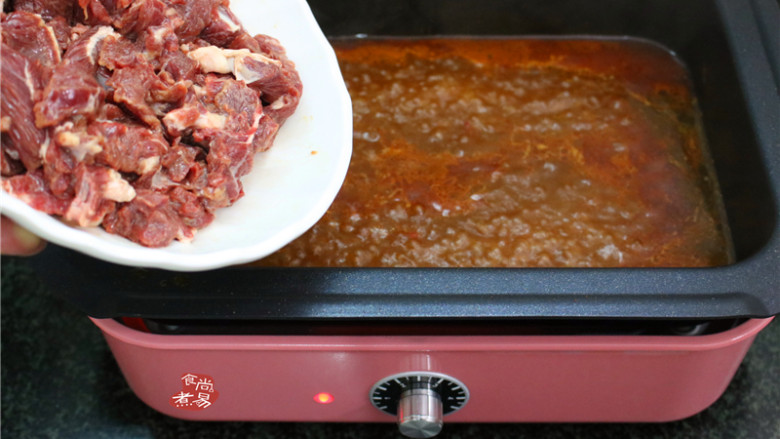 水煮牛肉,汤汁再次沸腾,将腌制上浆的牛肉均匀倒入锅里煮