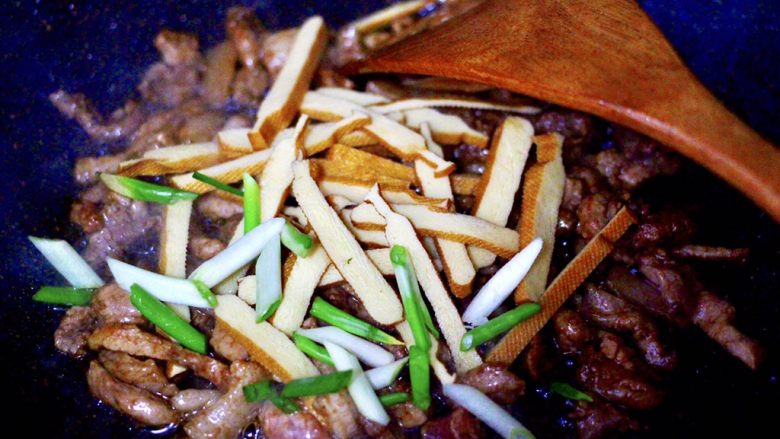 香干肉丝炒韭菜,加入切片的香干和小香葱,大火翻炒均匀。