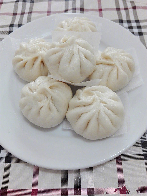 肉包子,快速揭开锅盖以防水滴在包子上面,盛入盘中。