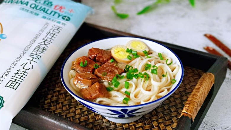 红烧牛肉空心面,煮熟的面放入牛腩汤碗中,马上牛腩,鹌鹑蛋从中间切开放入碗中,撒上葱花。