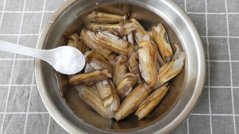 金牌葱姜巧烹蛏,把<a style='color:red;display:inline-block;' href='/shicai/ 202'>蛏子</a>放在水盆里,加一点盐浸泡1小时,让它吐净泥沙,搓洗干净。