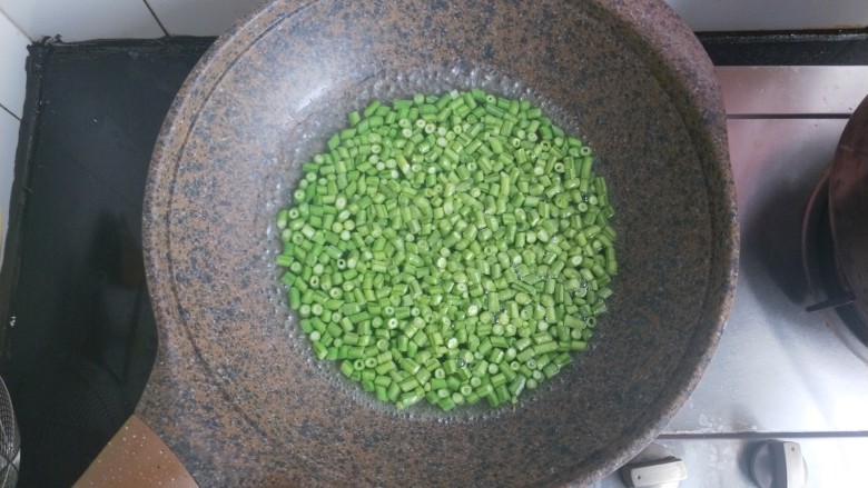 肉沫豆角,锅内烧水,水开后放入豆角煮至七成熟。煮的时候加几滴食用油。