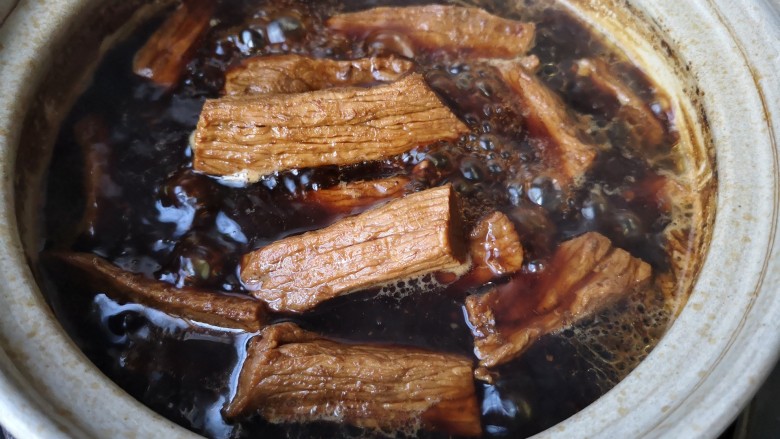 牛肉干,调小火,加盖焖煮1个半小时,中途开盖观察一下,如果水少了就适量补充热水,并适量加入一点老抽酱油。