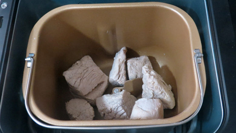 用面包机轻松做出自己喜欢口味的放心【猪肉松】,煮好的肉倒入面包机桶中