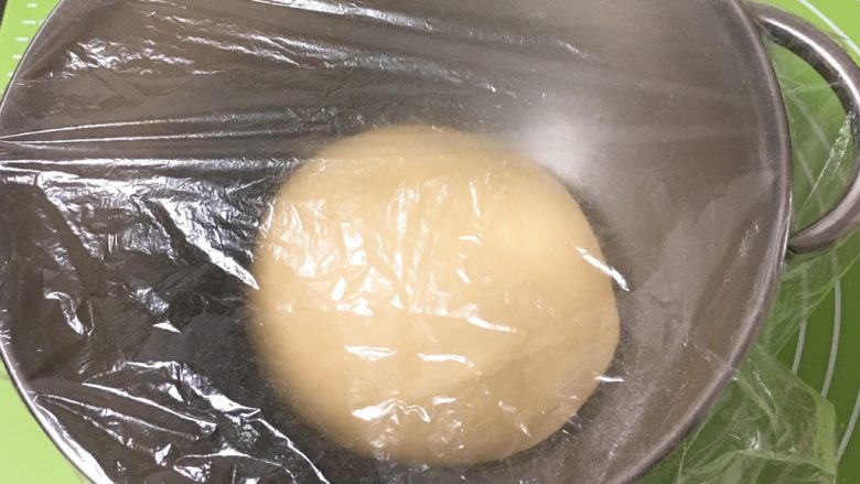 火腿片双吐司,滚圆后放入桶中,盖上保鲜膜。