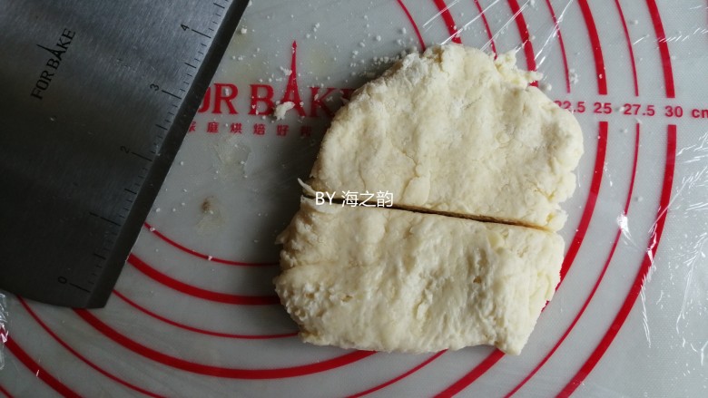 羊角司康,案板上铺一张保鲜膜,把面团倒在案板上,切成两份