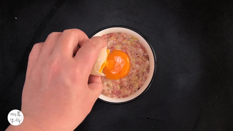 视频|松茸蒸肉饼|牛佤松茸食谱,把搅拌好的肉末,盛入浅碗中,将蛋黄倒在肉末上面,放入醒开的(牛佤)冻干松茸菌。