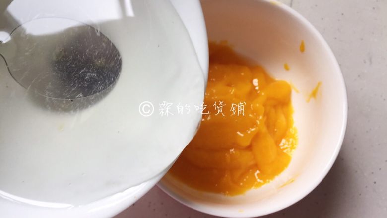 美美滴芒果慕斯,另外的一片吉利丁加50毫升的冷水泡软后,隔水加热搅拌至吉利丁融化,随后倒入剩余的果泥中。