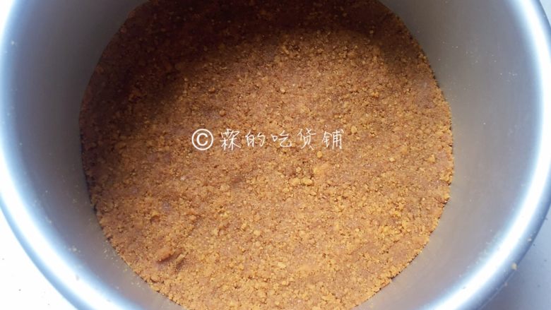 美美滴芒果慕斯,拌匀后的饼干碎倒入六寸蛋糕模中,用勺子背压平、压紧后冰箱冷藏。