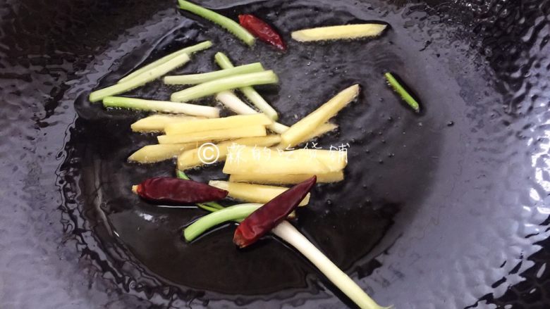 金牌葱姜巧烹蛏,随后,火开大,油温升至7成热,重新再放入葱白段、姜和干辣椒。