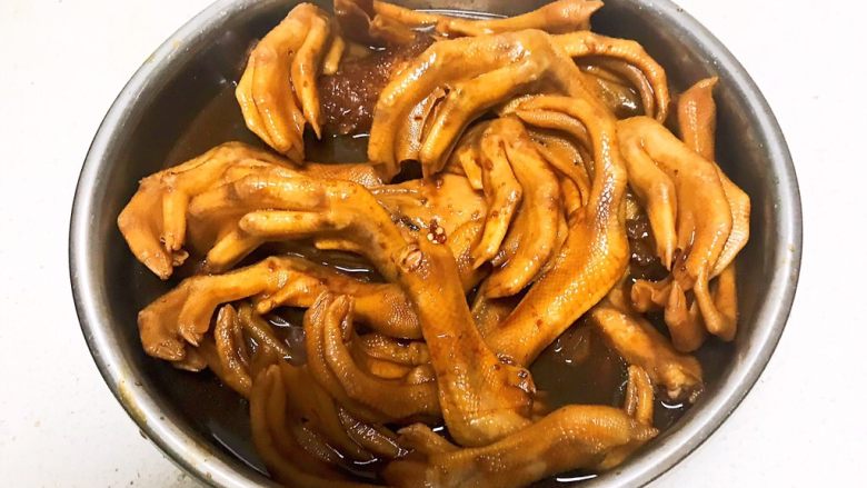 卤鸭爪,把卤汁捞出所有辅料后倒入盆中,继续浸泡3个小时左右