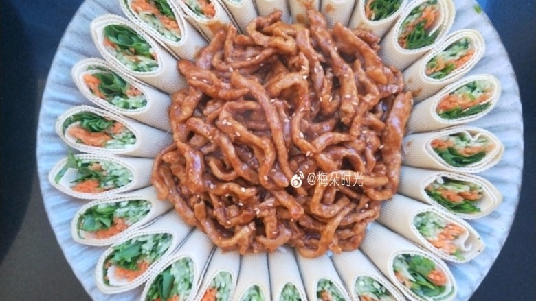 京酱肉丝,盛在豆腐卷里面,葱丝上面,撒少许熟白芝麻。