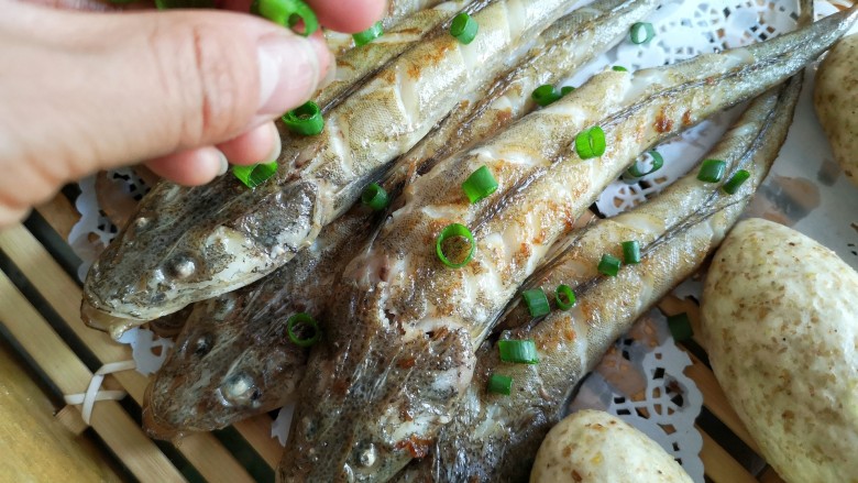 亚麻籽粉饽饽煎鱼,待两面都煎至金黄色后出锅装盘，撒适量葱花。