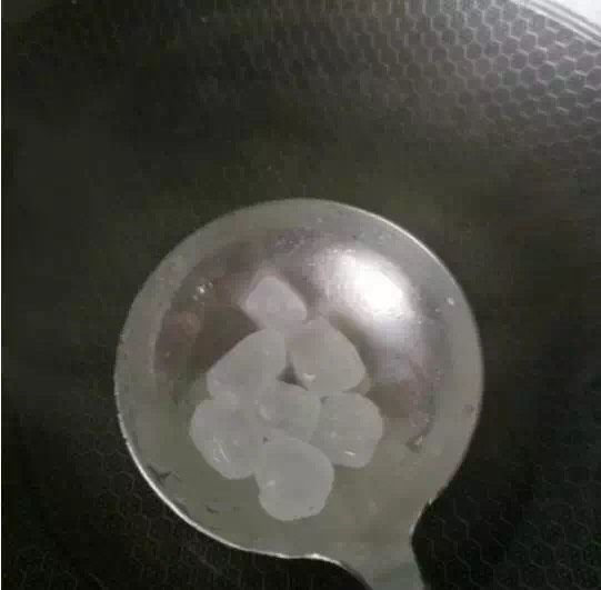 黄豆焖猪蹄,把锅里清洗干净,在锅内加入半勺的水,再放入6块冰糖开小火熬糖色
