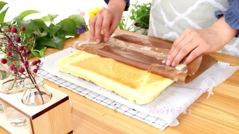香葱肉松蛋糕卷,倒扣在油纸上,揭掉油垫