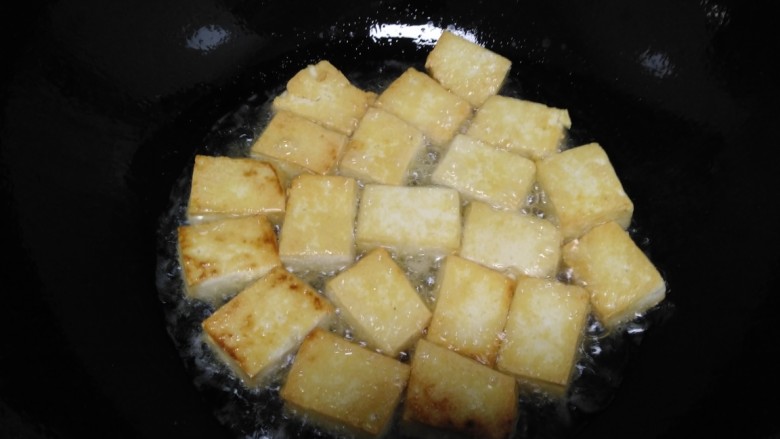 鸡肉豆腐炒蒜苔,锅中放入适量油,放入豆腐煎至两面金黄盛出。