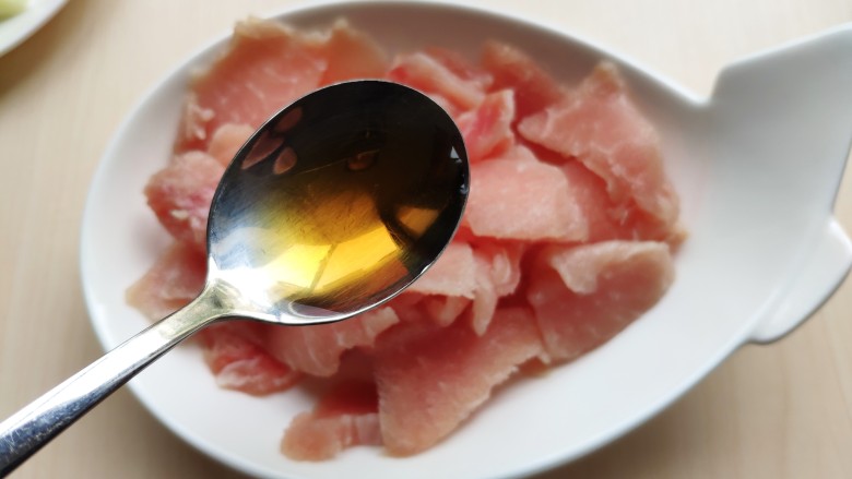 肉片番茄炒黄瓜,精肉切成肉片,加入<a style='color:red;display:inline-block;' href='/shicai/ 718'>料酒</a>拌匀。