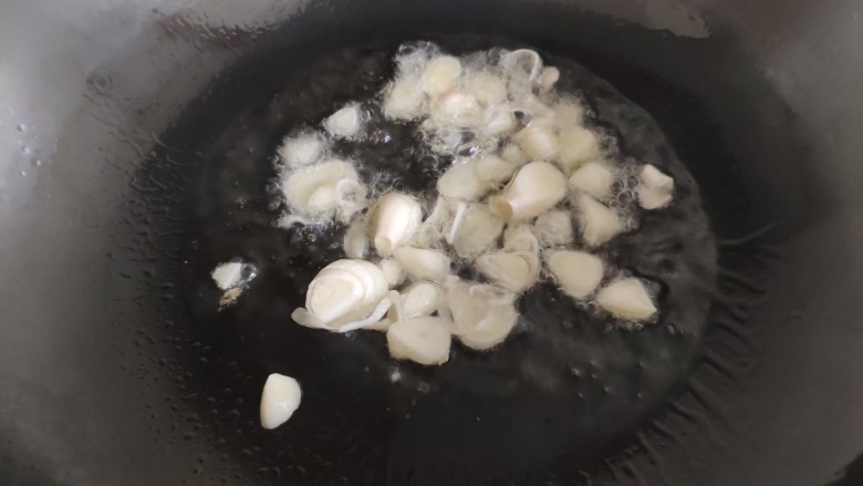 肉片番茄炒黄瓜,炒锅油热后,先加入一半的大蒜爆锅。